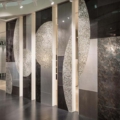Sicis Vetrite z kolekcji Vetrite Art model Saturno Contro Silver to wielkoformatowy panel szklany o wymiarach 120x350 cm, 60x350 cm, 90x350 cm, 60x350 cm. Kolory tego modelu to: brązowy, srebrny, szary, a możliwe wykończenia powierzchni: Satin.