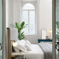 Stolik nocny Scappini Home Away, szary, z jedną szufladą, blat z lakierowanego szkła, wykończenie mosiężne, wyściełany ekoskórą.